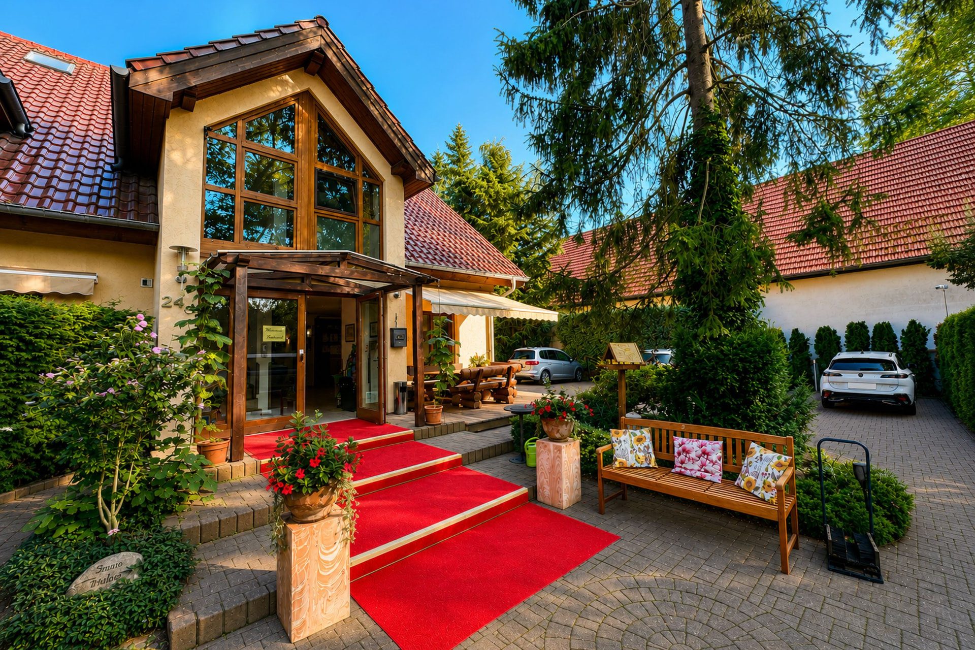 Entrance area of Hotel Potsdam am Katharinenholz with red carpet and car park