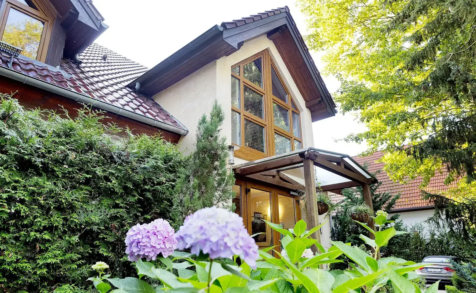 Außenansicht des Hotel am Katharinenholz in Potsdam mit Parkplatz am Haus