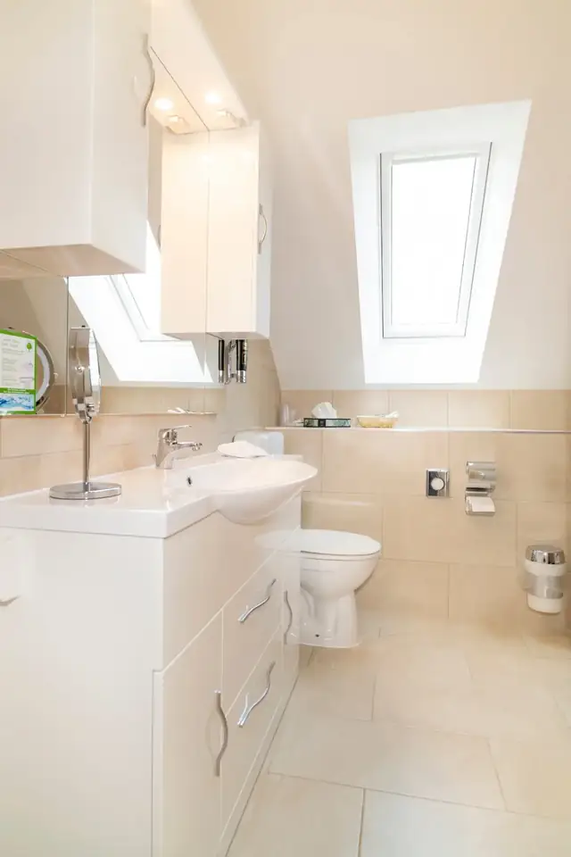 Bathroom of the attic suite with vanity, toilet and skylight – Hotel am Katharinenholz Potsdam