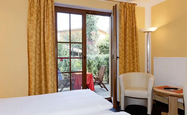 Blick aus dem Doppelzimmer auf die eigene Terrasse mit Gartenmöbeln – Hotel Potsdam am Katharinenholz