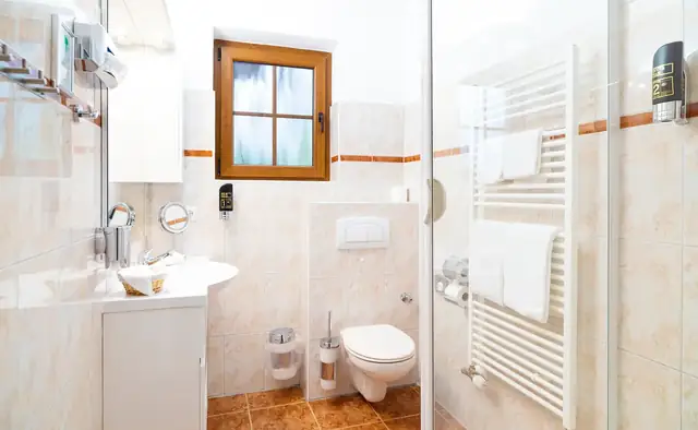Badezimmer im Doppelzimmer mit Waschtisch, WC, Dusche und Kosmetikspiegel – Hotel Potsdam am Katharinenholz
