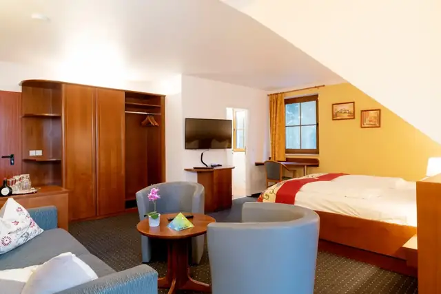 Superior room with sofa, armchairs, wardrobe and flat-screen TV – Hotel Potsdam am Katharinenholz
