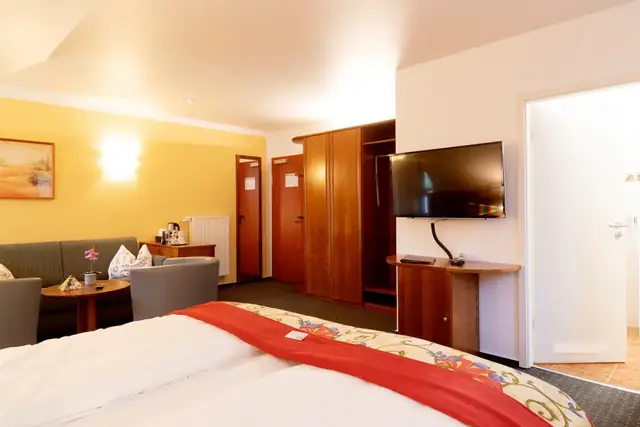 Spacious Superior room with double bed, seating area and large flat-screen TV – Hotel Potsdam am Katharinenholz