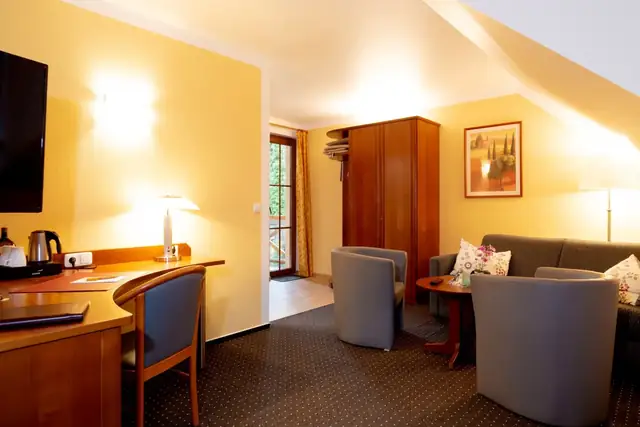 Workspace with desk, kettle and seating area in the Superior room – Hotel Potsdam am Katharinenholz
